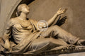 Statue of a woman in a classical pose with outstretched arm, made of marble.